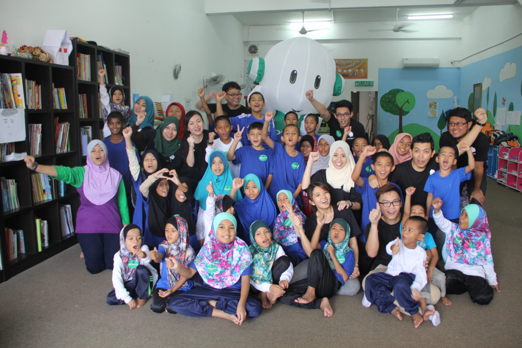 OPPO staff and volunteers taking a group picture with children from  Rumah Safiyyah