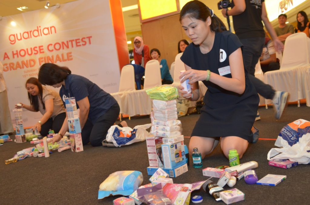 guardian-wah-finalists-stacking-a-tower-with-products-to-win-the-grand-prize-house